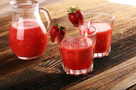 Glass of Sweet fresh strawberry juice and fresh strawberries on table. Healthy food and drink concept with fruitsの写真素材
