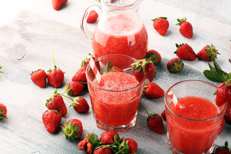Glass of Sweet fresh strawberry juice and fresh strawberries on table. Healthy food and drink concept with fruitsの写真素材