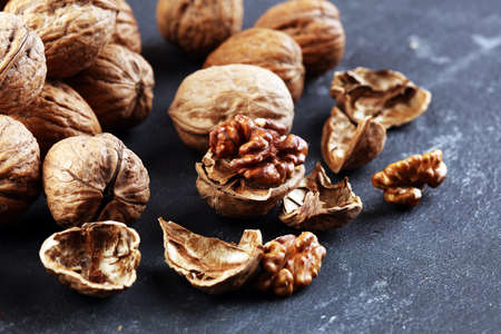 Walnut kernels and whole healthy walnuts on rustic old tableの写真素材