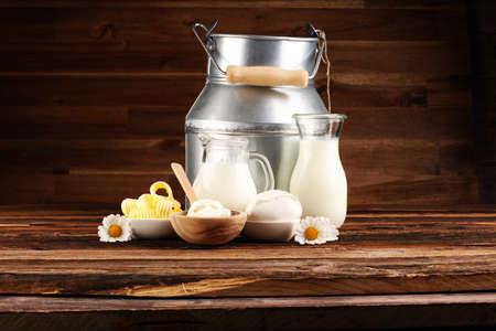 milk products. tasty healthy dairy products on a table on. mozzarella in a bowl, cottage cheese bowl, butter swirls and glass bottle の写真素材