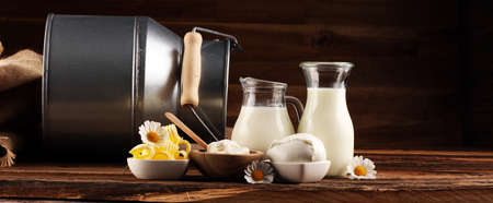 milk products. tasty healthy dairy products on a table on. mozzarella in a bowl, cottage cheese bowl, butter swirls and glass bottle の写真素材