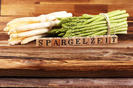 Healthy fresh White and green asparagus on vintage background with the german word Spargelzeit in wooden letter.の写真素材