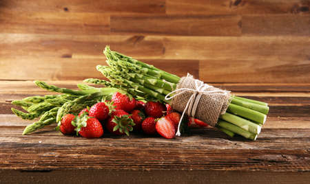 green fresh asparagus with a bunch of healthy strawberriesの写真素材