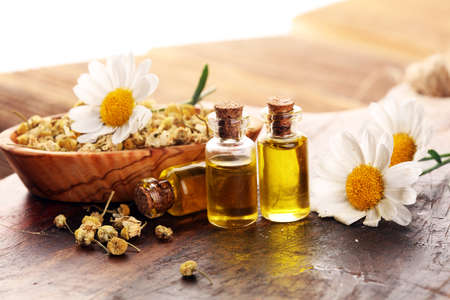 Chamomile Composition with essential oil and chamomile flowers on rustic wooden tableの写真素材