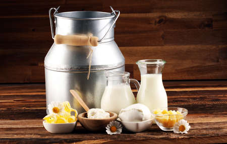 milk products. tasty healthy dairy products on a table on. mozzarella in a bowl, cottage cheese bowl, butter swirls and glass bottleの写真素材