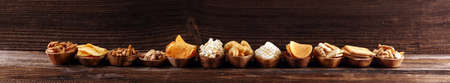 Salty snacks. Pretzels, chips, crackers in wooden bowls. Unhealthy products. food bad for figure, skin, heart and teeth. Assortment of fast carbohydrates food. の写真素材