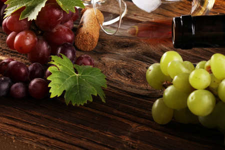 red Wine glass and white wine with grapes on rustic background の写真素材