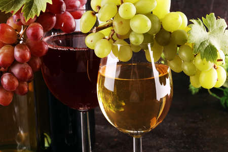 red Wine glass and white wine with grapes on rustic background の写真素材