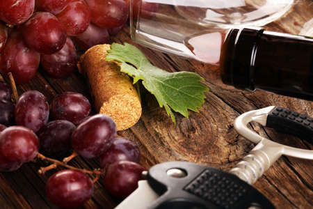 red Wine with red grapes and bottle on rustic background の写真素材