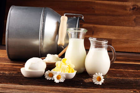 milk products. tasty healthy dairy products on a table on. mozzarella in a bowl, cottage cheese bowl, butter swirls and glass bottle の写真素材