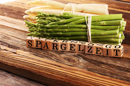 Healthy fresh White and green asparagus on vintage background with the german word Spargelzeit in wooden letter. の写真素材