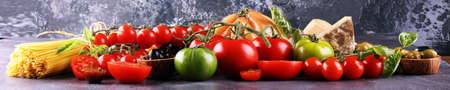 Tomatoes, Pasta, vegetables, herbs and spices for Italian food on tableの写真素材