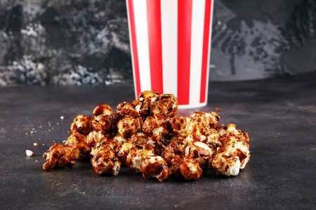 Tasty popcorn with caramel in cups on tableの写真素材