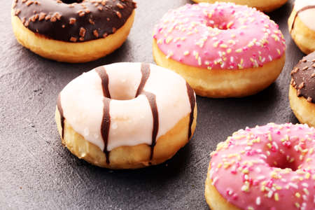 assorted donuts with chocolate frosted, pink glazed and sprinkles donuts.の写真素材