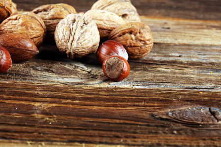mixed nuts on grey background. Healthy food and snack. Walnut, pecan, almonds, hazelnuts. vegan healthy eatingの写真素材