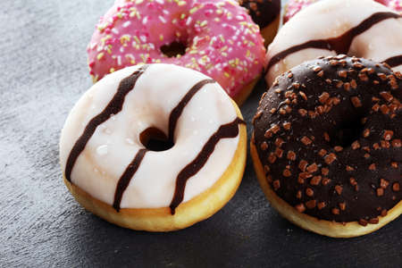 assorted donuts with chocolate frosted, pink glazed and sprinkles donuts.の写真素材
