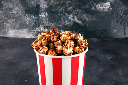 Tasty popcorn with caramel in cups on tableの写真素材