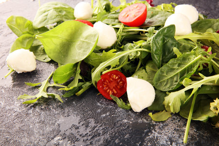 Mix fresh leaves of arugula, lettuce, spinach, beets for salad on rustic backgroundの写真素材