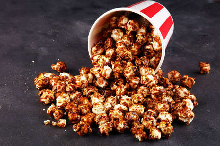 Tasty popcorn with caramel in cups on tableの写真素材