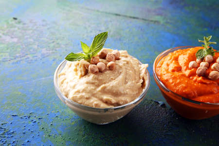 Different hummus bowls. Chickpea hummus, paprika hummus and lentils hummus on backgroundの写真素材