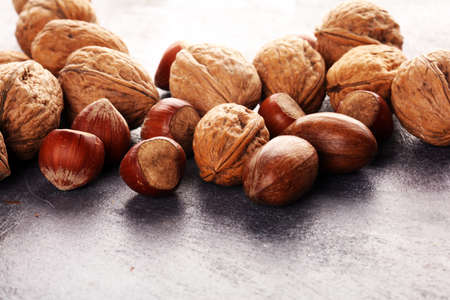 mixed nuts on grey background. Healthy food and snack. Walnut, pecan, almonds, hazelnuts. vegan healthy eatingの写真素材
