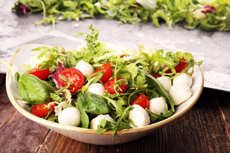Mix fresh leaves of arugula, lettuce, spinach, beets for salad on rustic backgroundの写真素材