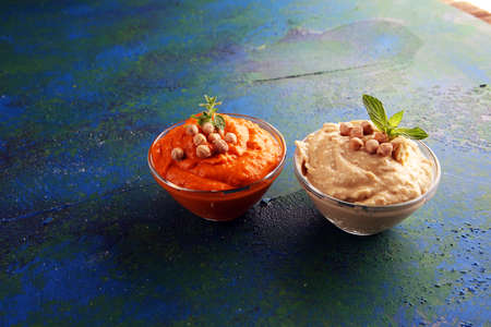 Different hummus bowls. Chickpea hummus, paprika hummus and lentils hummus on backgroundの写真素材