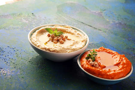 Different hummus bowls. Chickpea hummus, paprika hummus and lentils hummus on backgroundの写真素材