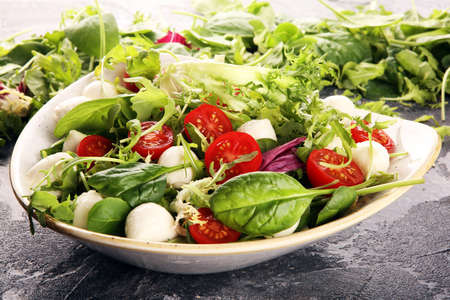 Mix fresh leaves of arugula, lettuce, spinach, beets for salad on rustic backgroundの写真素材