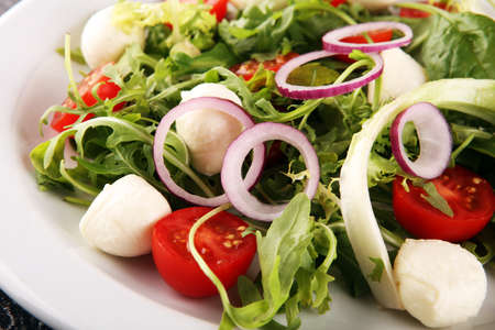 Mix fresh leaves of arugula, lettuce, spinach, beets for salad on rustic backgroundの写真素材