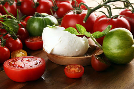 Caprese salad with tomatoes, mozzarella and organic basil.の写真素材