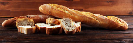 baguette baked bread and sliced baguette on wooden backgroundの写真素材