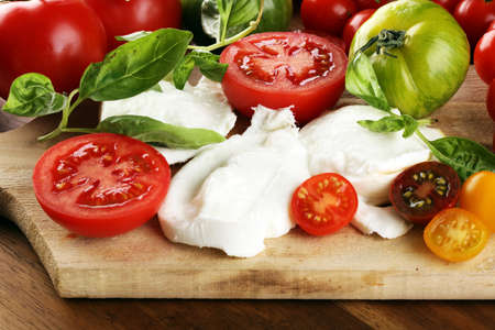 Caprese salad with tomatoes, mozzarella and organic basil.の写真素材