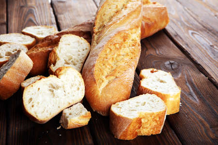 baguette baked bread and sliced baguette on wooden backgroundの写真素材