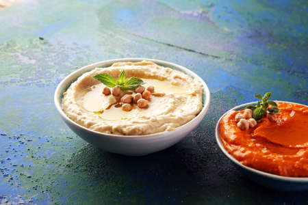 Different hummus bowls. Chickpea hummus, paprika hummus and lentils hummus on backgroundの写真素材