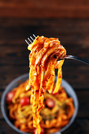 tagliatelle pasta with tomato sauce parmesan basil on rustic table