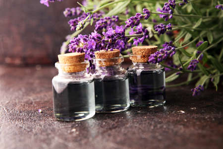 Glass bottle of Lavender essential oil with fresh lavender flowers for healthy aromatherapy spa massage concept.の写真素材