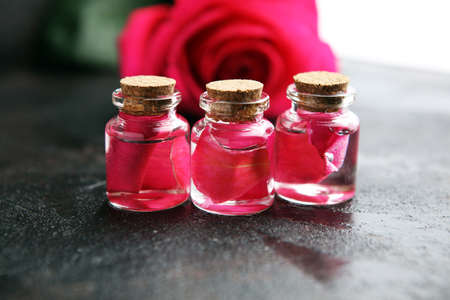 pink rose flower and glass of bottle essential oil. spa and aromatherapy cosmetic concept on backgroundの写真素材