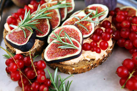 Healthy sweet figs fruit toast with cheese, honey and flower. Fresh fig fruit and flower decoration.の写真素材