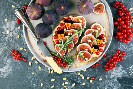 Healthy sweet figs fruit toast with cheese, honey and flower. Fresh fig fruit and flower decoration.