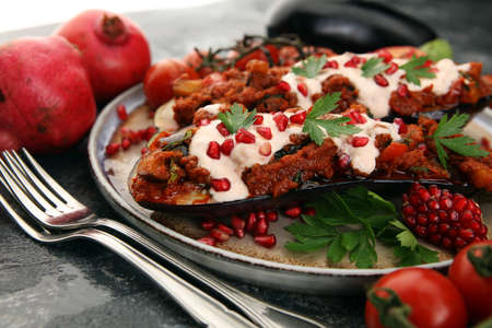 Baked eggplant with tomatoes, garlic and paprika and pomegranate on dark backgroundの写真素材