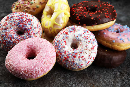 assorted donuts with chocolate frosted, pink glazed and sprinkles donuts.の写真素材