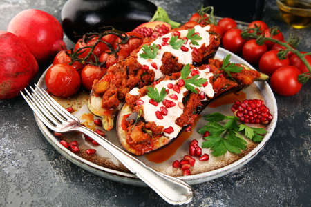 Baked eggplant with tomatoes, garlic and paprika and pomegranate on dark backgroundの写真素材