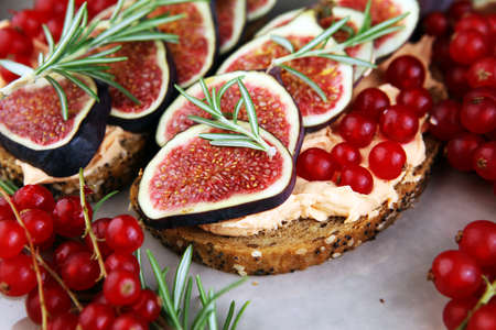 Healthy sweet figs fruit toast with cheese, honey and flower. Fresh fig fruit and flower decoration.の写真素材