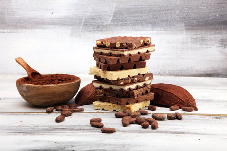 Chocolate bars on white background with chocolate towerの写真素材