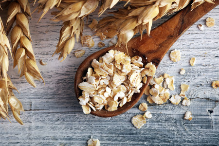 Oat flakes or rolled oats and golden ears of wheat. Healthy lifestyle, healthy eating, vegan diet conceptの写真素材