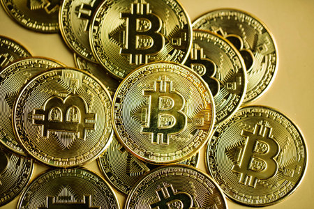 Image of stack of bitcoins against golden background. Cryptocurrency concept.