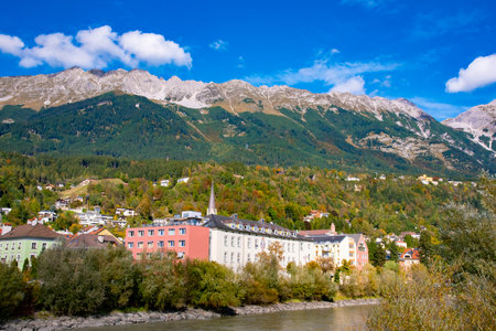 View of colorful houses along the Inn river with mountains and a cloudy sky in the background. Taken in Innsbruck, Austria on October 15 2016のeditorial素材