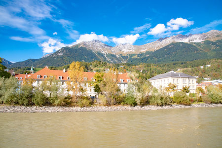 View of colorful houses along the Inn river with mountains and a cloudy sky in the background. Taken in Innsbruck, Austria on October 15 2016のeditorial素材