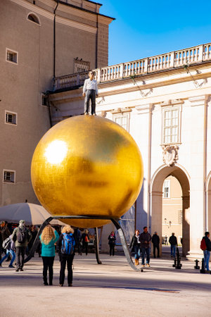 Kapitelplatz square with a sculpture of a man on a golden sphere in Salzburg City. Taken in Salzburg, Austria, October 20, 2016のeditorial素材